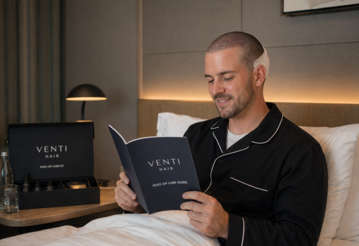 A patient reviewing the Venti Hair Post-Op Care Guide and care kit in a premium recovery room.